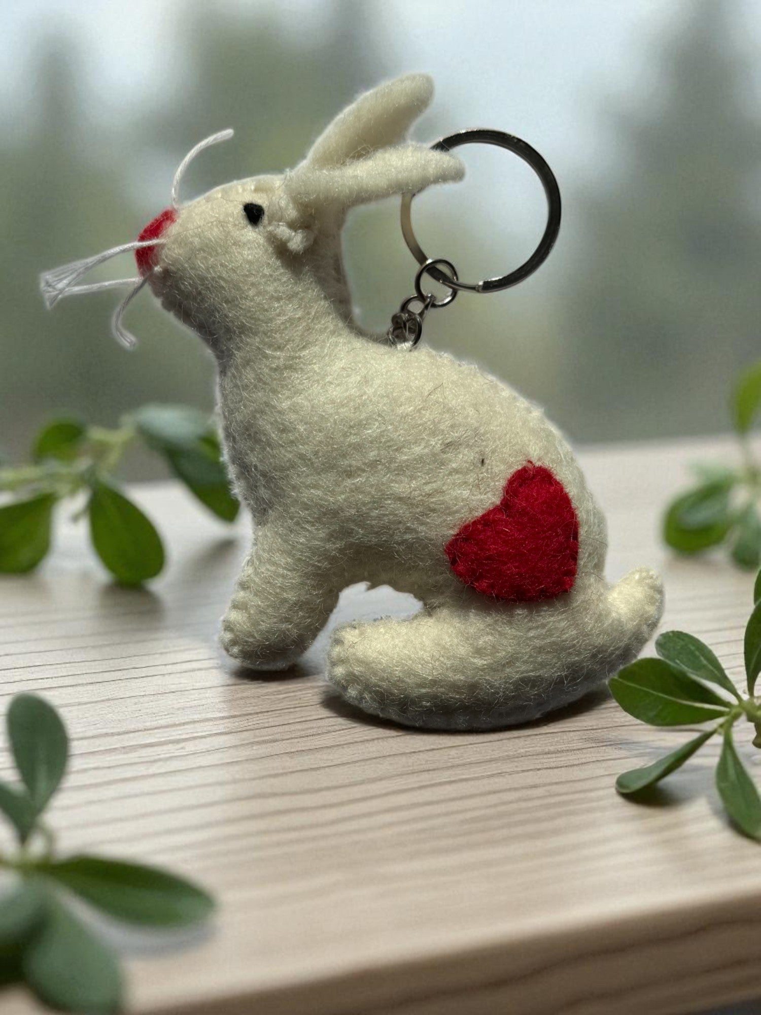 Handmade felt keychain featuring a white bunny with heart by artisans in Nepal, fair trade and eco-friendly
