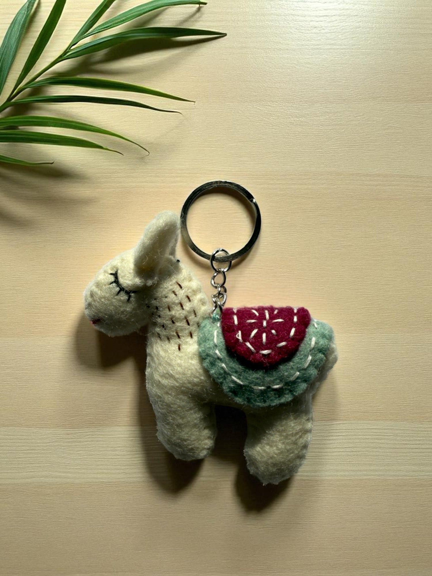 Handmade felt keychain featuring a white lhama by artisans in Nepal, fair trade and eco-friendly