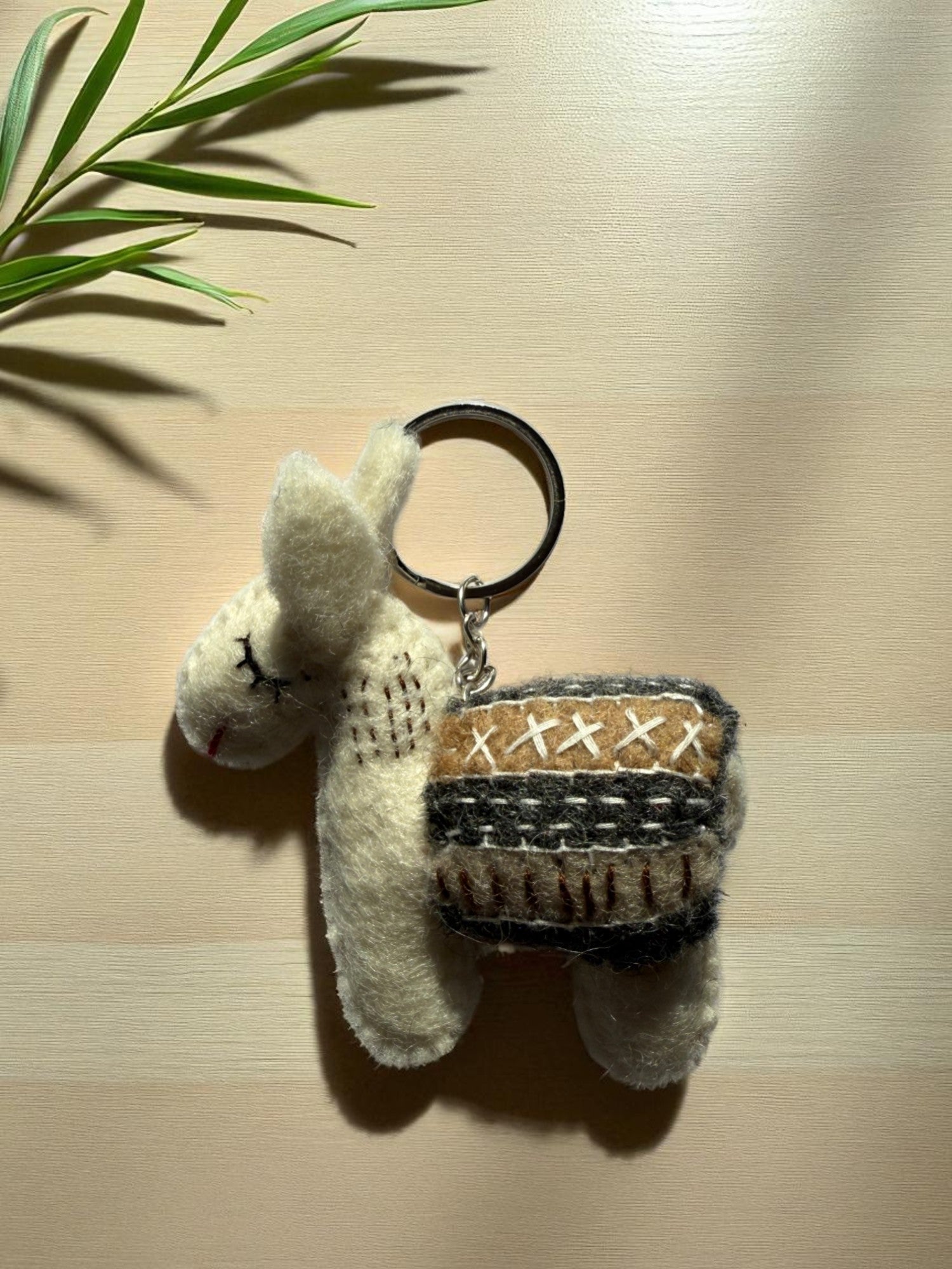 Handmade felt keychain featuring a white lhama by artisans in Nepal, fair trade and eco-friendly