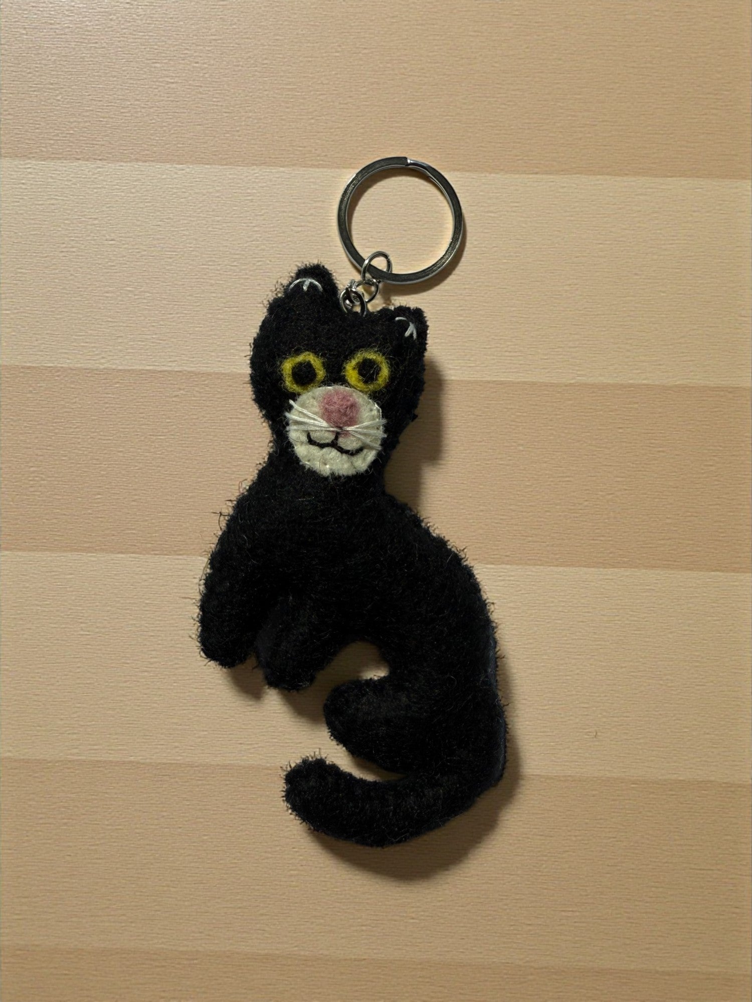 Handmade felt keychain featuring a black cat by artisans in Nepal, fair trade and eco-friendly