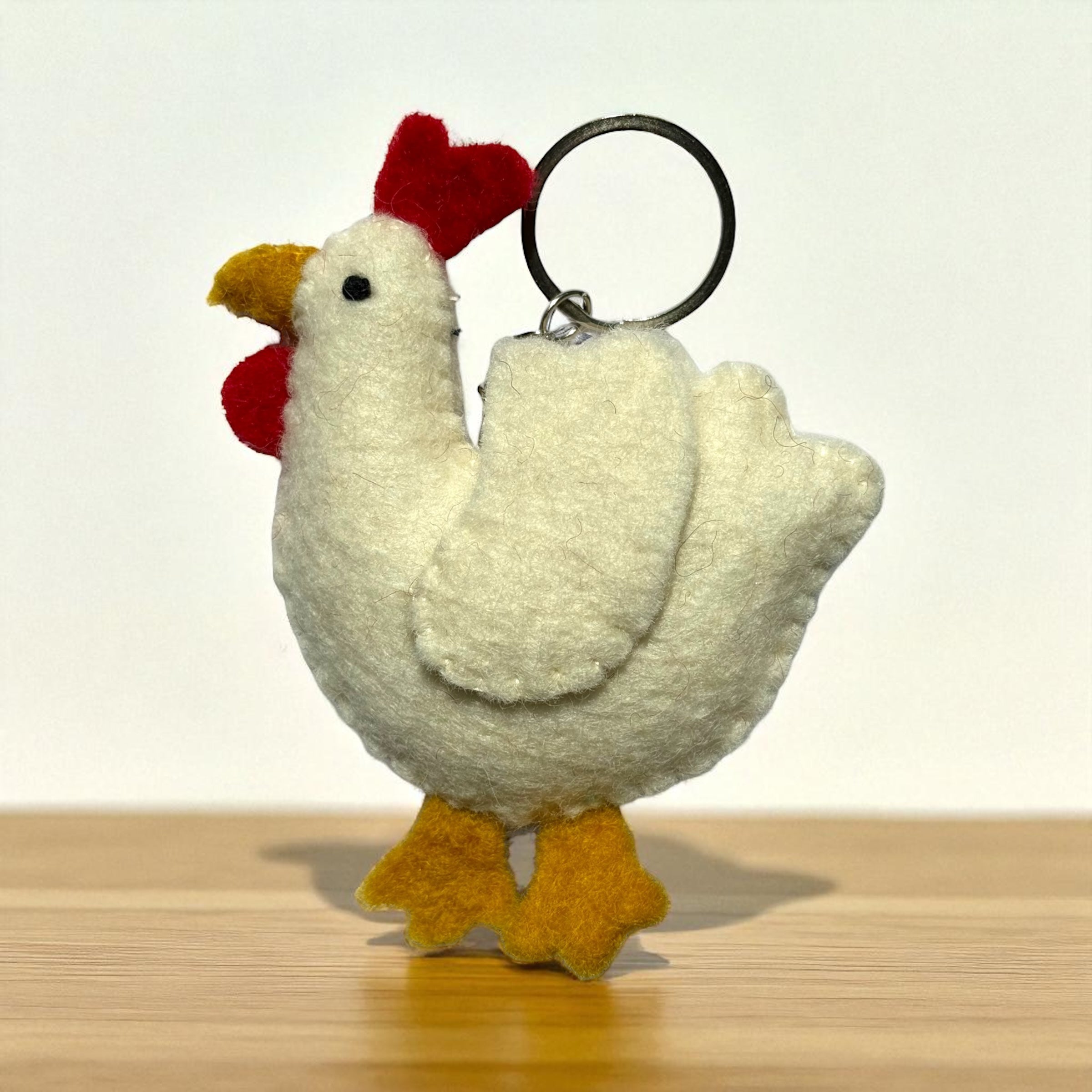 Handmade felt keychain featuring a white chicken crafted by artisans in Nepal, fair trade and eco-friendly