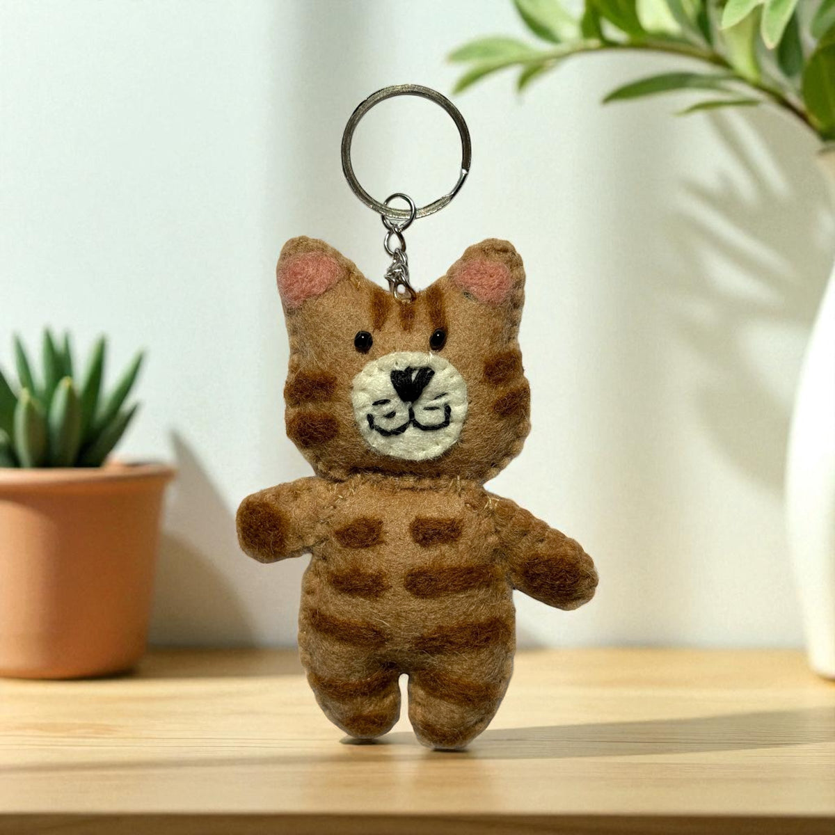 Handmade felt keychain featuring a striped cat crafted by artisans in Nepal, fair trade and eco-friendly