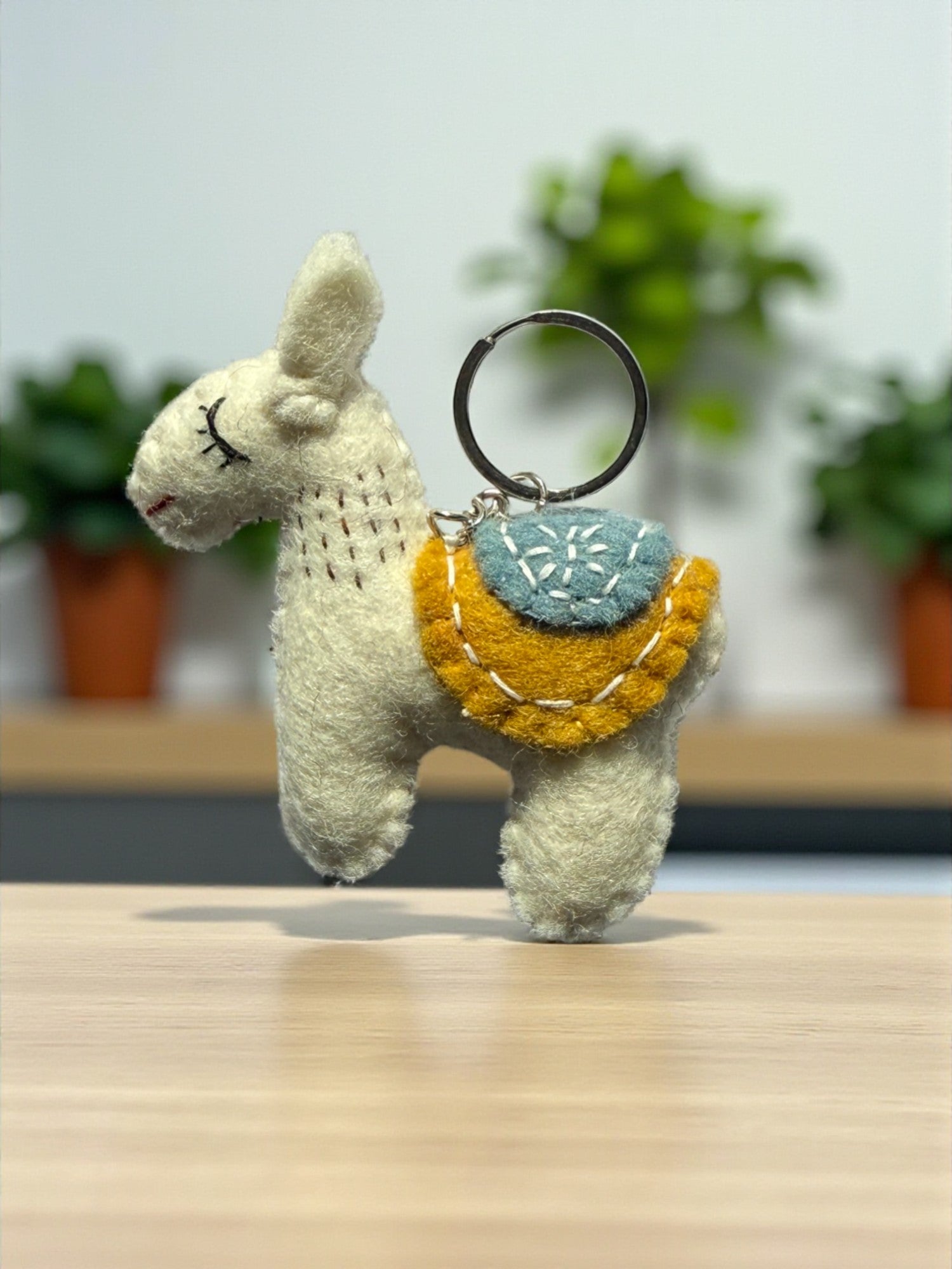 Handmade felt keychain featuring a white lhama by artisans in Nepal, fair trade and eco-friendly