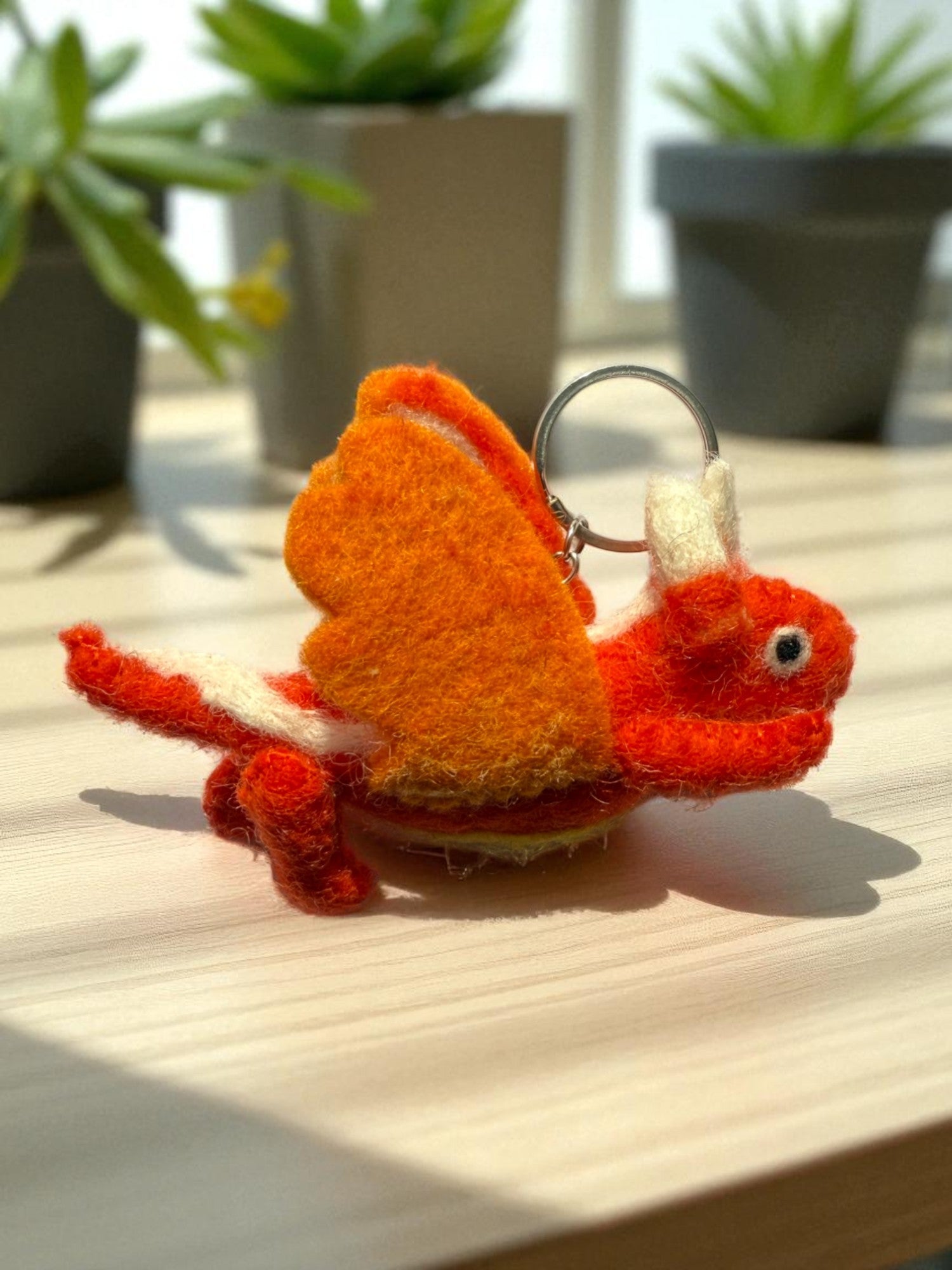 Handmade felt keychain featuring an orange dragon by artisans in Nepal, fair trade and eco-friendly