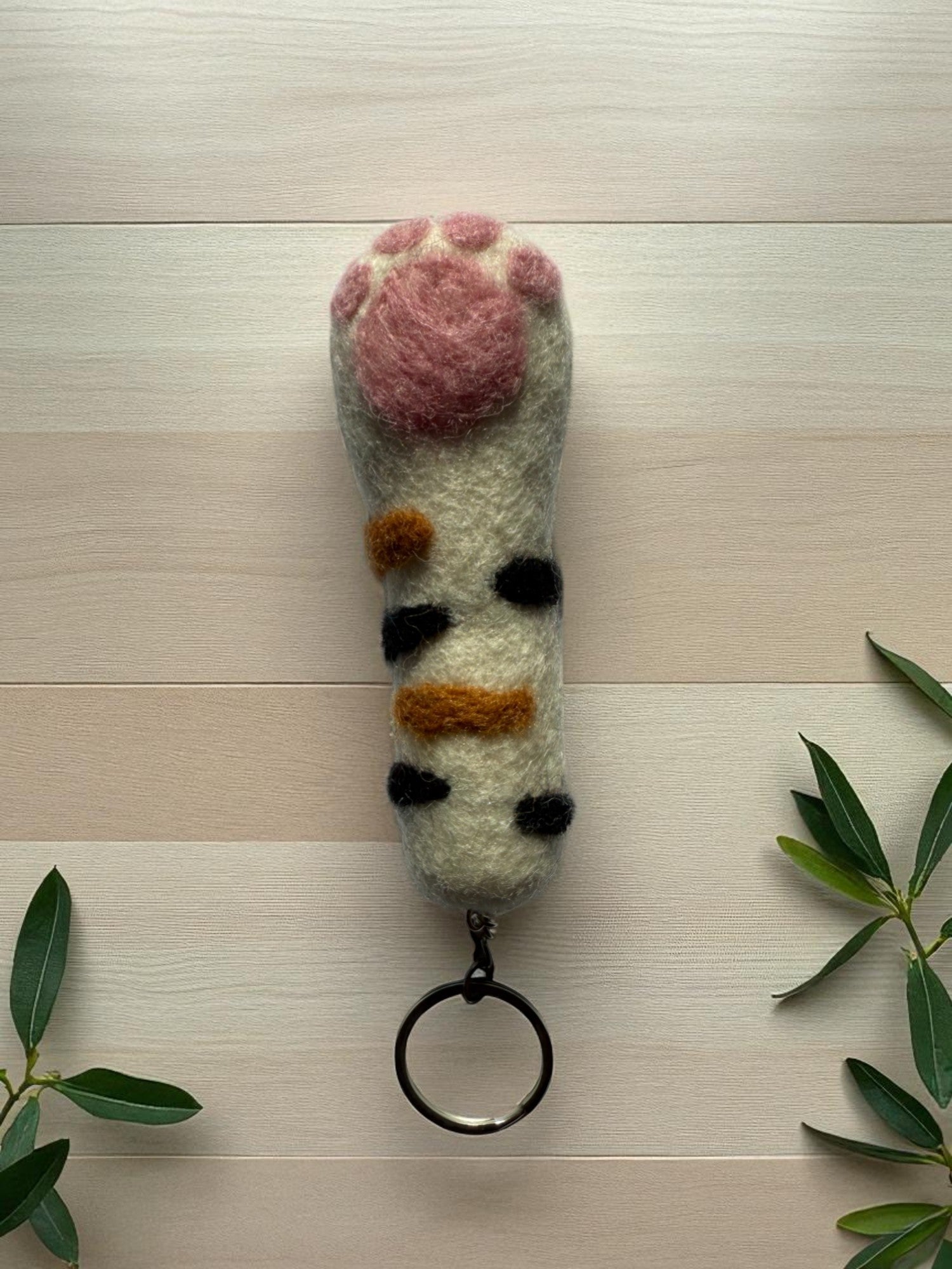 Handmade felt keychain featuring a striped paw by artisans in Nepal, fair trade and eco-friendly