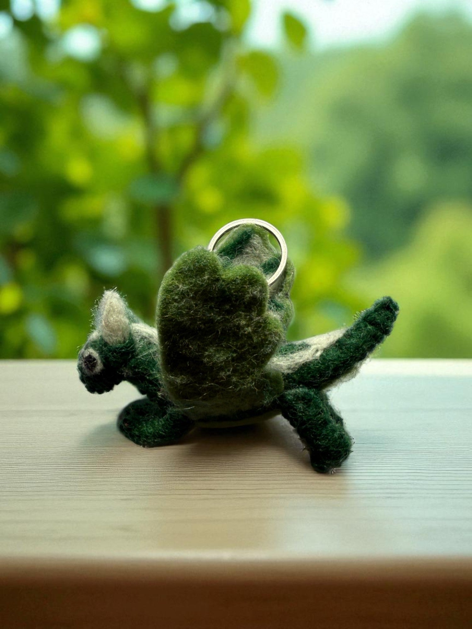 Handmade felt keychain featuring a green dragon by artisans in Nepal, fair trade and eco-friendly