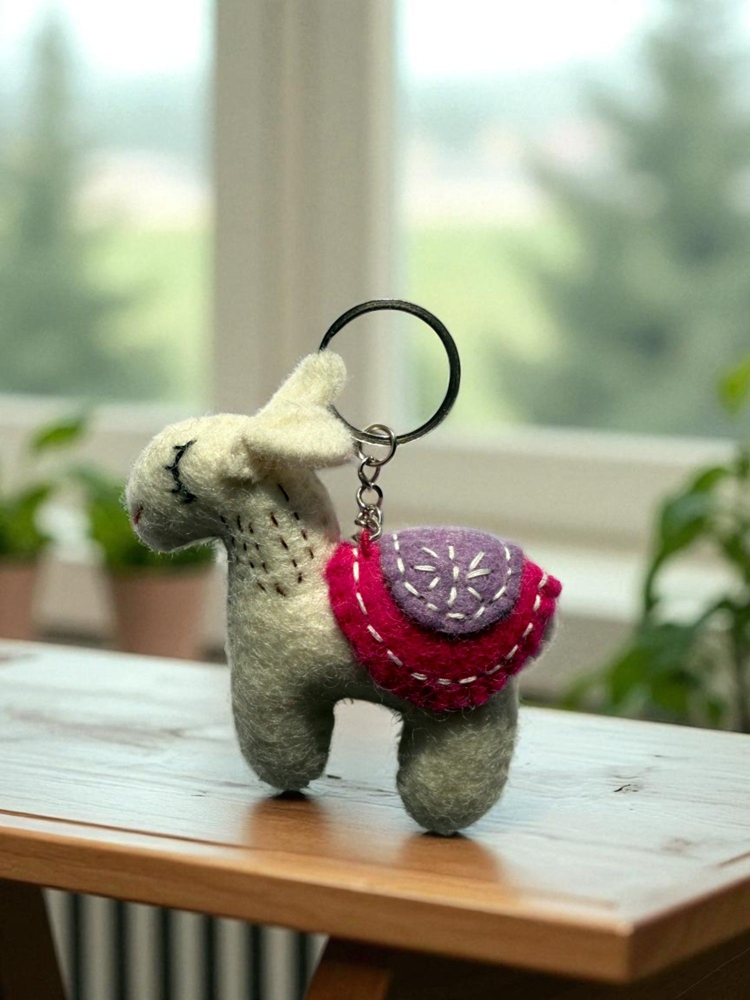 Handmade felt keychain featuring a white lhama by artisans in Nepal, fair trade and eco-friendly