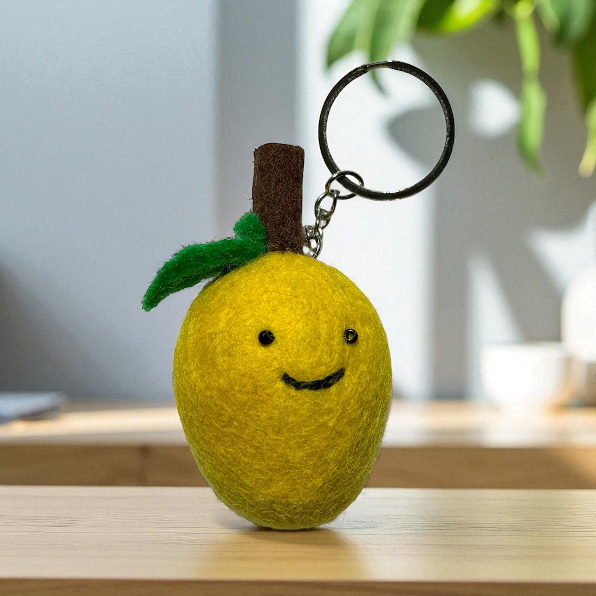 Handmade felt keychain featuring a yellow lemon crafted by artisans in Nepal, fair trade and eco-friendly