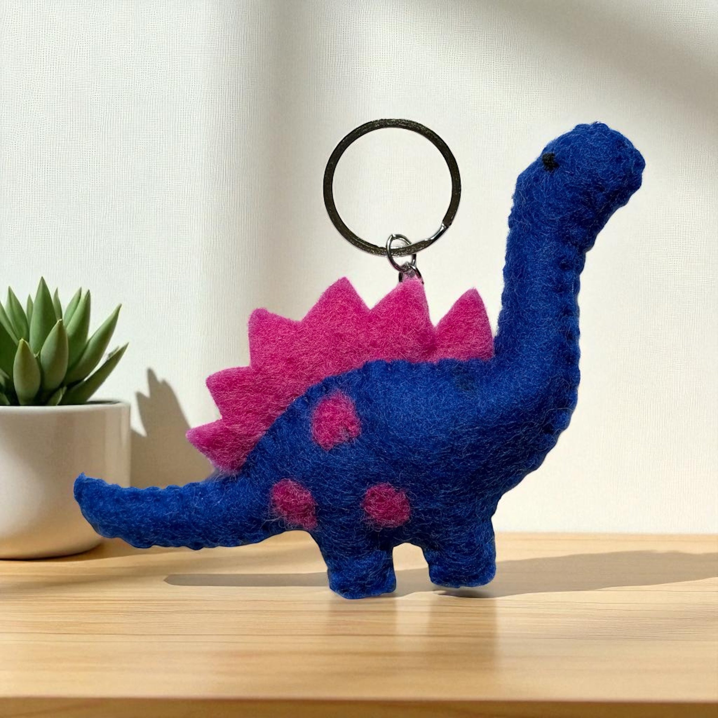 Handmade felt keychain featuring a blue dinosaur crafted by artisans in Nepal, fair trade and eco-friendly