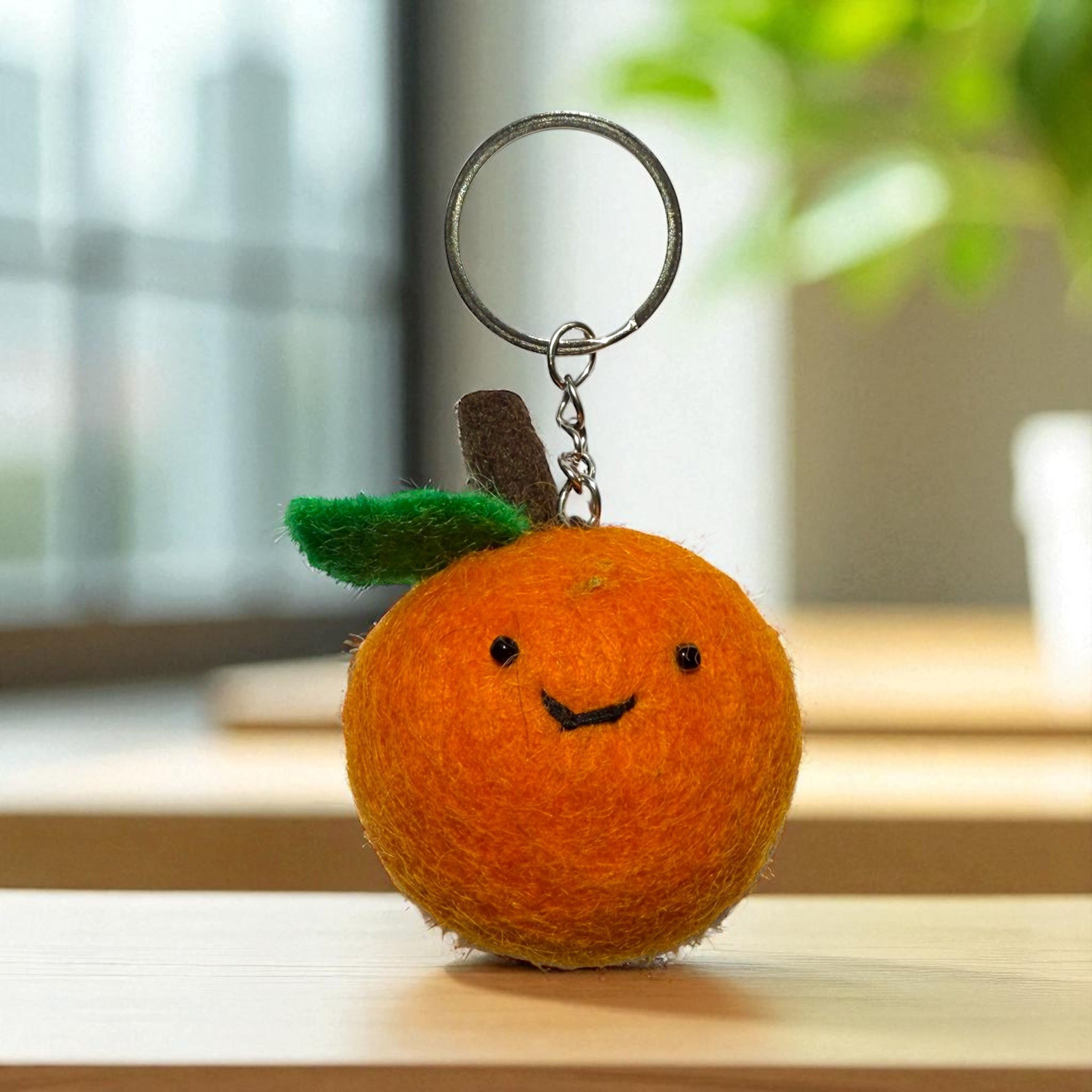 Handmade felt keychain featuring an orange crafted by artisans in Nepal, fair trade and eco-friendly