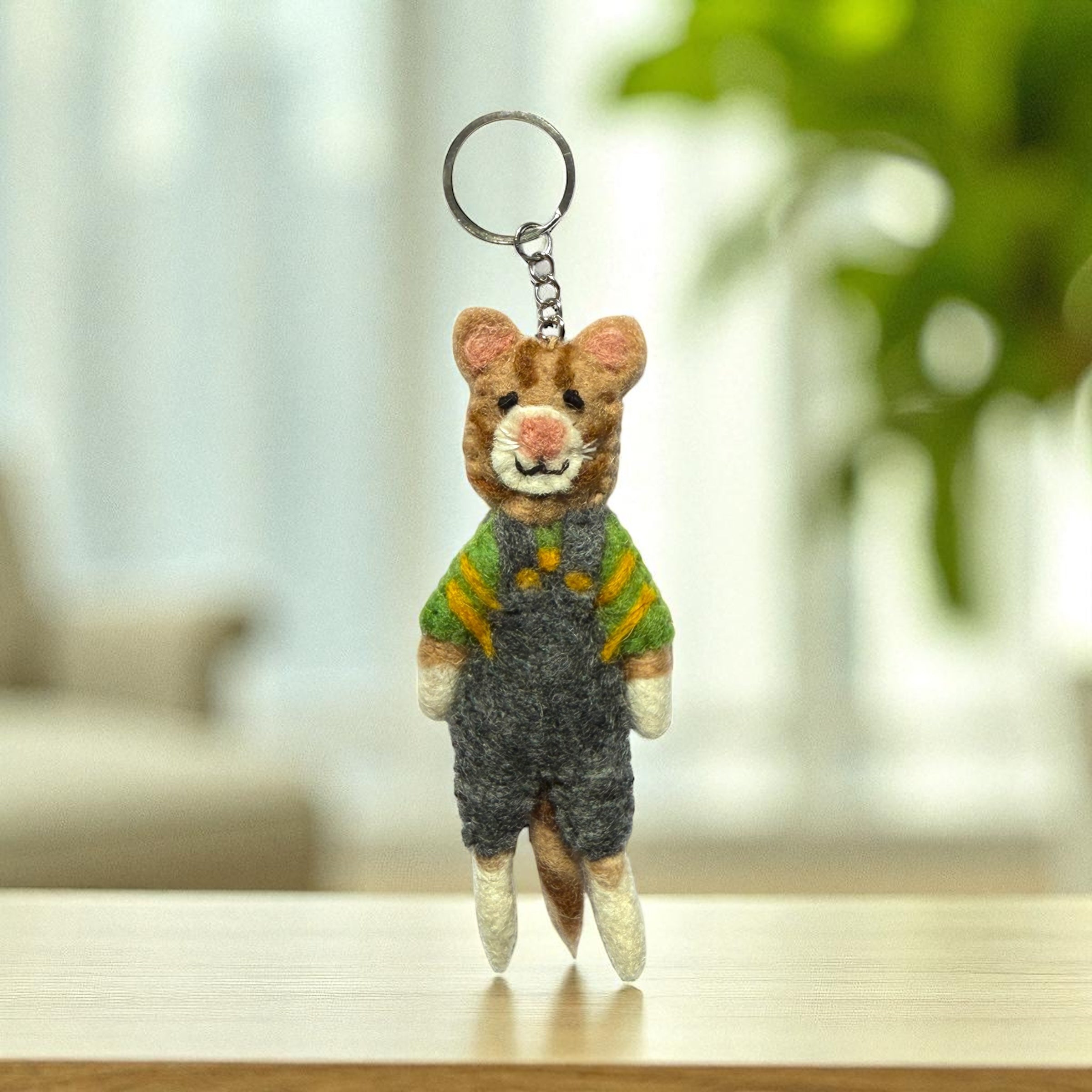Handmade felt cat keychain wearing green and yellow striped shirt with grey overalls, fair trade from Nepal