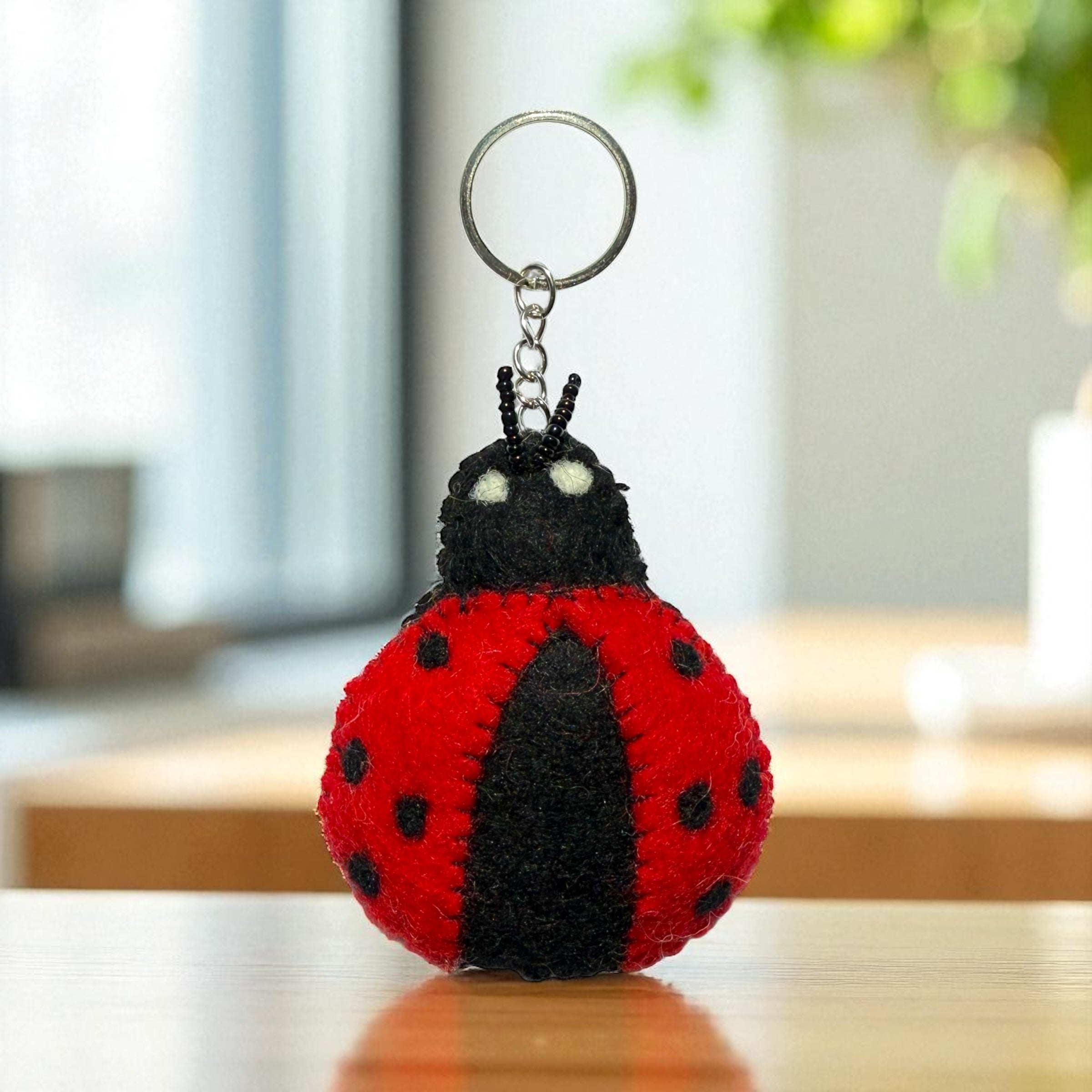 Handmade felt keychain featuring a red and black ladybug crafted by artisans in Nepal, fair trade and eco-friendly