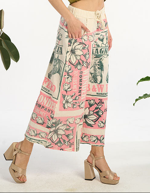 Woman wearing a horse with magnolia flowers wide leg plants with plants in the background