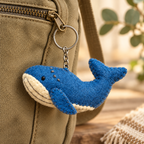 Handmade felt Blue Whale keychain displayed on a bag