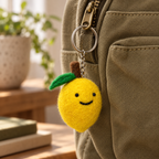 Handmade felt Lemon keychain displayed on a bag