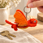 Handmade felt Orange Dragon keychain shown in a lifestyle setting