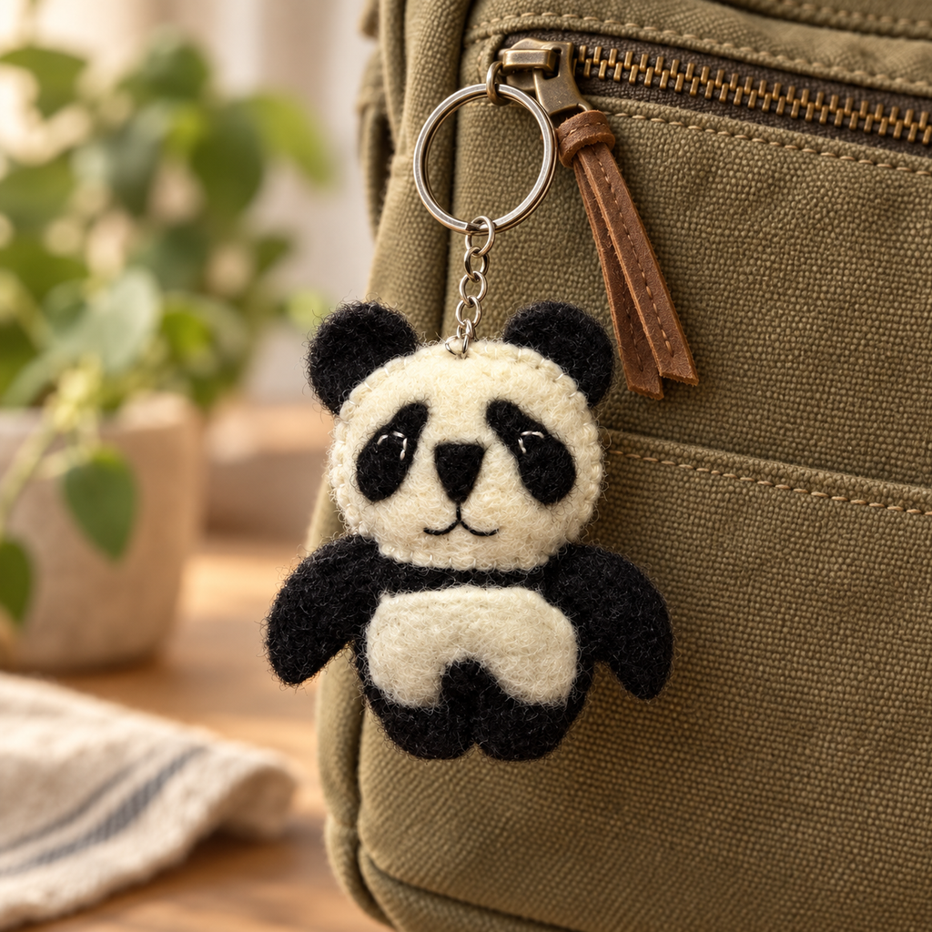 Handmade felt Panda keychain displayed on a bag