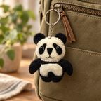 Handmade felt Panda keychain displayed on a bag