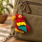 Handmade felt Parrot keychain displayed on a bag