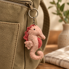 Handmade felt Seahorse keychain displayed on a bag
