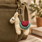 Handmade felt White Blue Llama keychain displayed on a bag