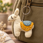 Handmade felt White Yellow Llama keychain displayed on a bag